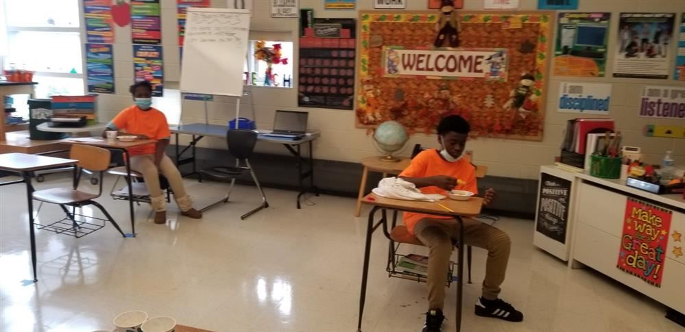  Students sitting at desks eating nachos